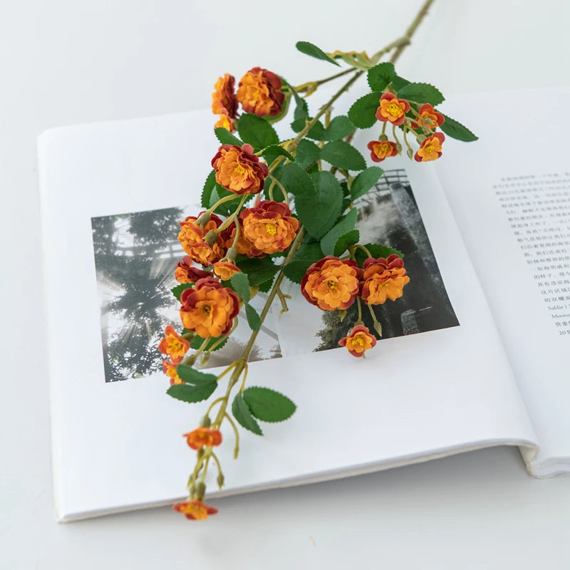 Orange flowers on an open book with a black and white photo inside