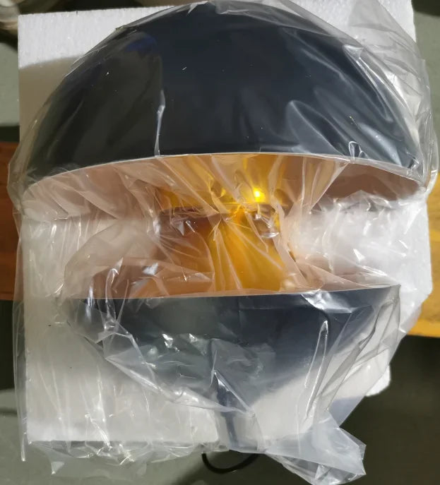 Black and yellow lampshade wrapped in clear plastic