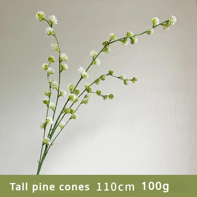 Tall pine cone branch with green and white cones on a plain background