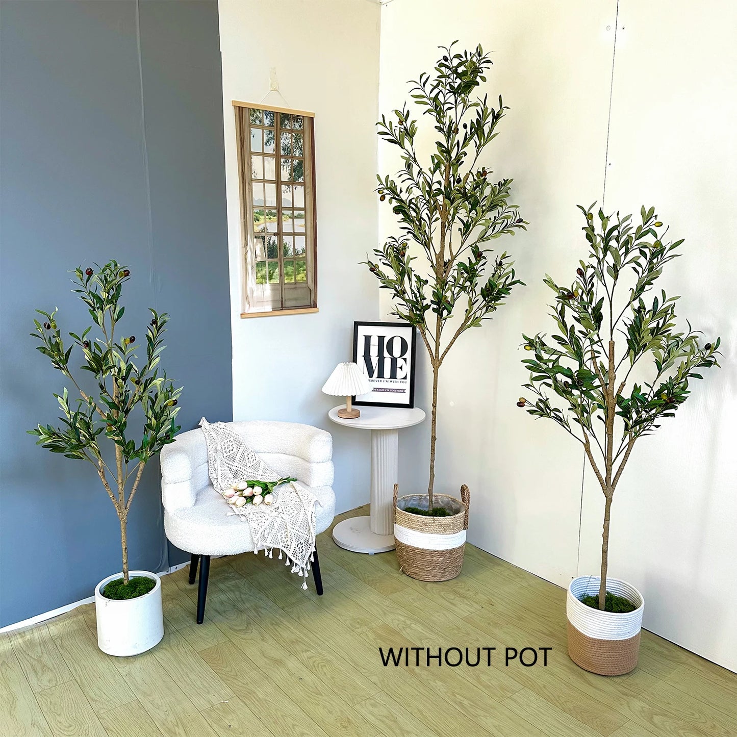 Three potted plants in a room with a chair and table.