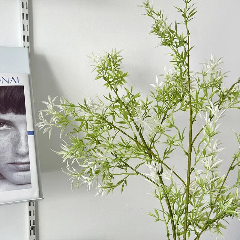 Artificial plant with a magazine featuring a person on a white wall