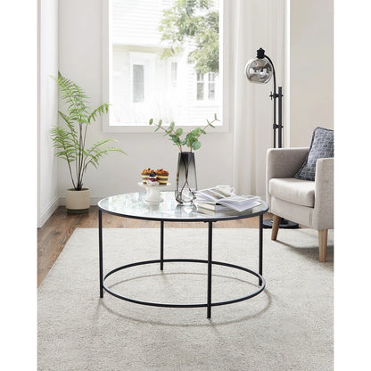 Round glass coffee table with black metal frame in a living room setting.
