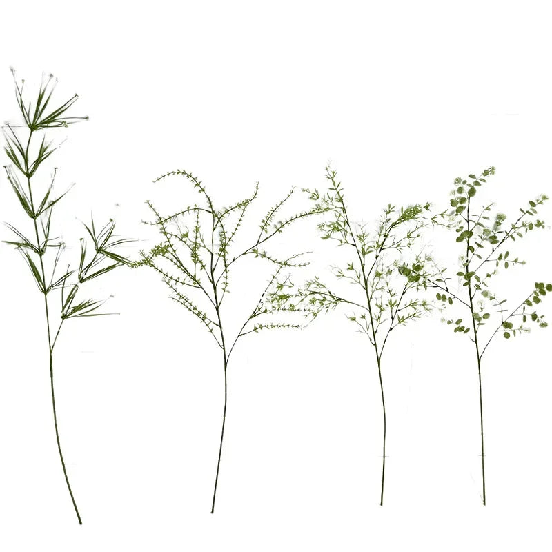 Set of four green artificial plants on a white background