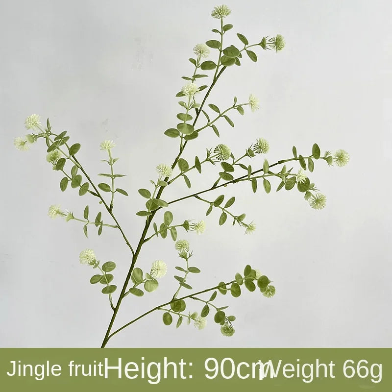 Artificial greenery branch with leaves and buds on a light gray background