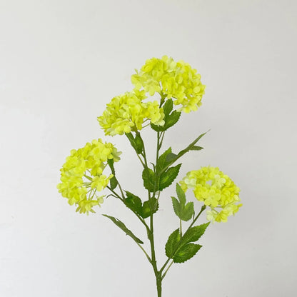 Artificial flower branch with bright yellow flowers on a light gray background